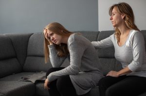 Photo of depressed teen and mother on the couch prior to attending family therapy in katy, tx 77494 at the counseling center at cinco ranch