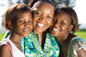 african american mother with two teen daughters smiling at the camera after family therapy with a counselor in katy, tx 77494 at The counseling center at cinco ranch