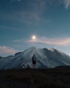 depressed man standing in front of mountain