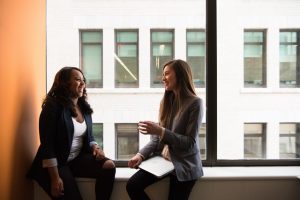 two women talking at work and building friendships after learning how through therapy