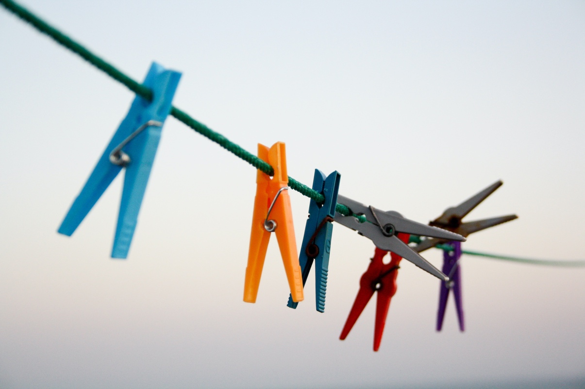 Different colored clothespins on a string, where the grey one stands out and looks different. Represents the need for talk therapy for individuals with autism in Katy, TX 77494