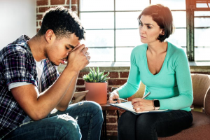 A female therapist conducting talk therapy with a young male teen that was diagnosed with ASD. 