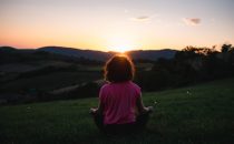 A woman meditating at sunset on a mountain. Represents the need for self-awareness counseling in Katy, TX 77494