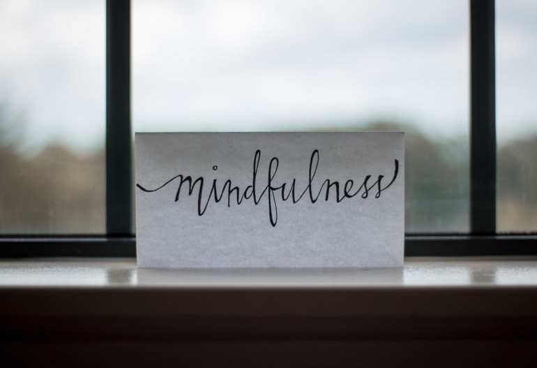 mindfulness written on a piece of paper in front of a window, How to Regulate Your Emotions blog, begin counseling today in katy texas at the counseling center at cinco ranch