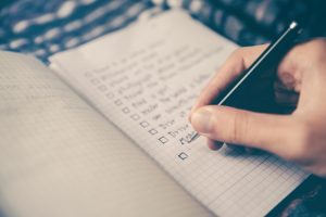 Man or woman writing or completing a to do list with pen and paper, Effective time management blog, counseling center at cinco ranch, katy texas