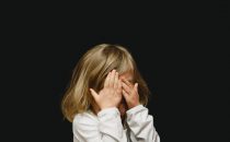 little girl child covering her face perhaps experiencing pain or negative thinking, How to Counteract Negative Thinking Errors in Children blog, the counseling center at cinco ranch, katy texas 77494