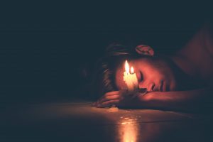 girl on the floor with a candle burning, burning the candle at both ends, depression blog, signs to look for, counseling center at cinco ranch, katy texas 77494